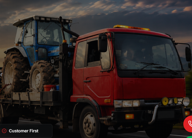 Red towing lorry carrying heavy machinery